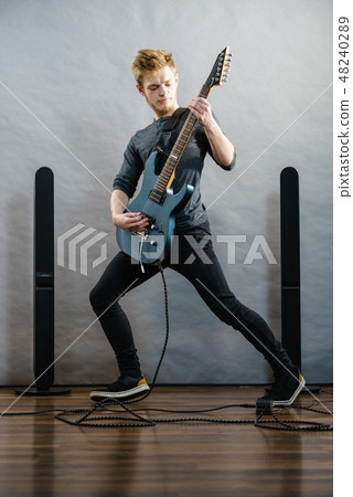 Young man playing electric guitar Young man playing electric guitar 48240289