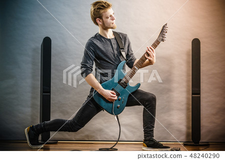 Young man playing electric guitar 48240290