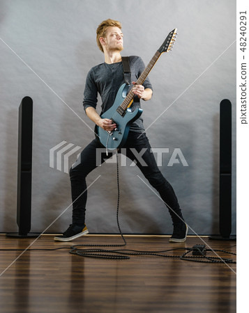 Young man playing electric guitar Young man playing electric guitar 48240291