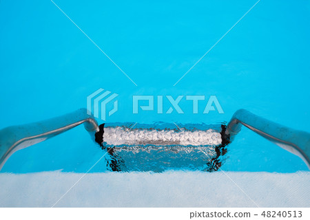 Ladder in an uneasy water of a swimming pool 48240513