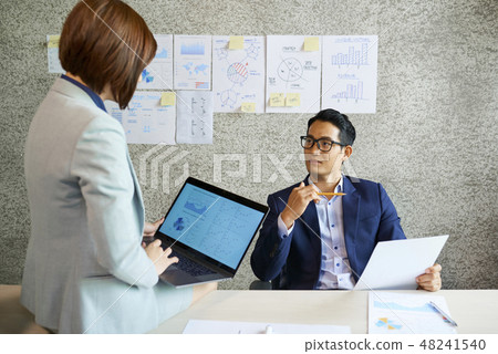 Businessman listening to coworker at meeting Businessman listening to coworker at meeting 48241540