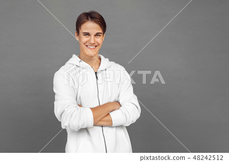 Freestyle. Teenager boy standing isolated on grey crossed arms smiling cheerful 48242512