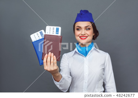 Professional Occupation. Stewardess standing isolated on grey with passports and tickets close-up 48242677