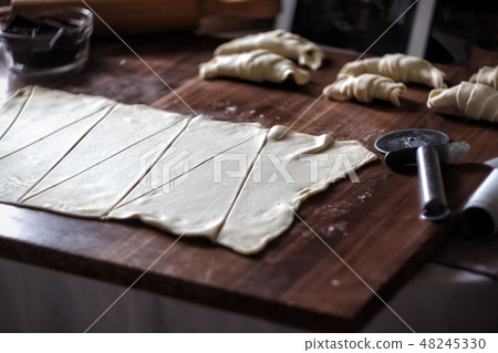 Cut the dough into triangles for croissants with chocolate 48245330