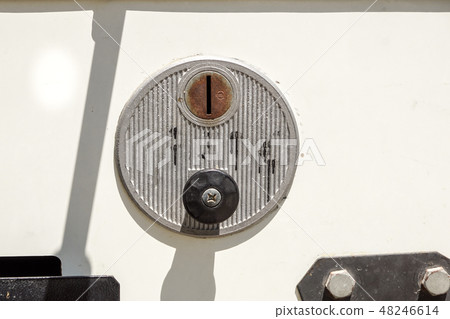 A closeup of a metal coin slot panel from a coin operated machine with entry and exit slots A closeup of a metal coin slot panel from a coin operated machine with entry and exit slots 48246614
