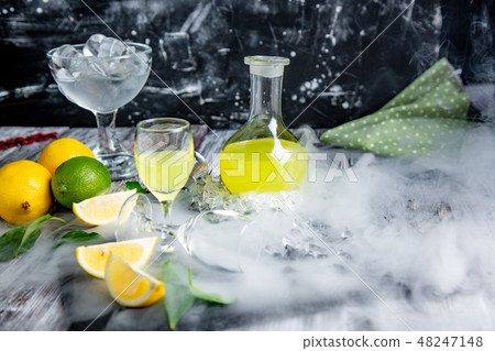 Italian typical digestive limoncello with fresh lemons in smoke, selective focus 48247148