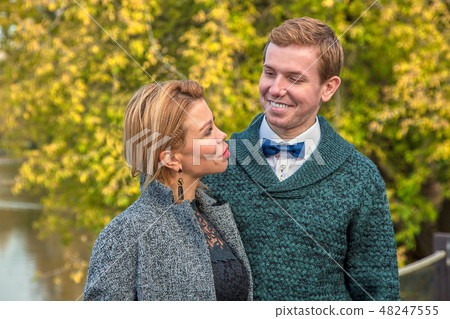 Romantic couple relaxing in autumn park, cuddling, kissing, enjoying fresh air, beautiful nature 48247555