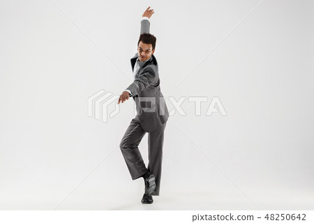 Happy businessman dancing isolated on gray studio background Happy businessman dancing isolated on gray studio background 48250642