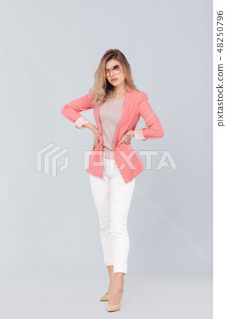 blonde woman in pastel casual jacket posing in studio. 48250796