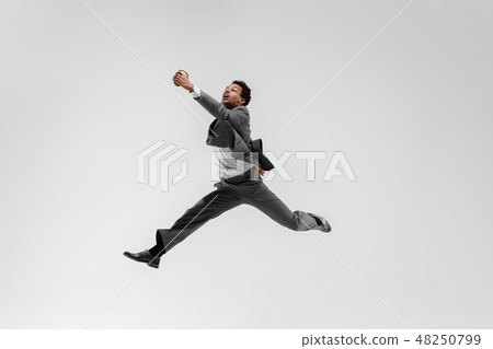 Happy businessman dancing isolated on gray studio background Happy businessman dancing isolated on gray studio background 48250799