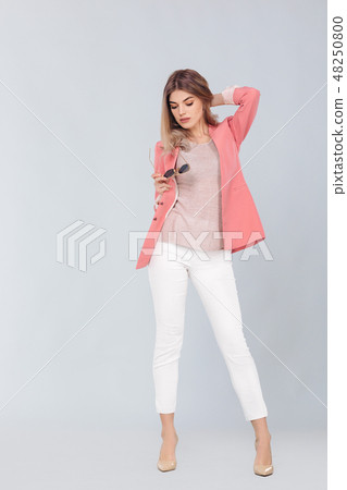 blonde woman in pastel casual jacket posing in studio. 48250800