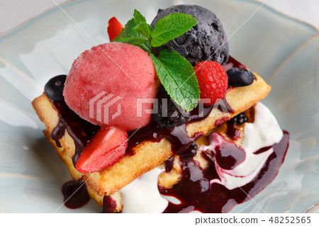 Plate of belgian waffles with ice cream and fresh berries 48252565