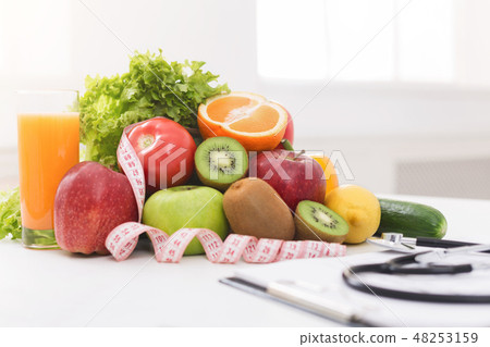 Nutritionist desk with healthy fruit and stethoscope Nutritionist desk with healthy fruit and stethoscope 48253159