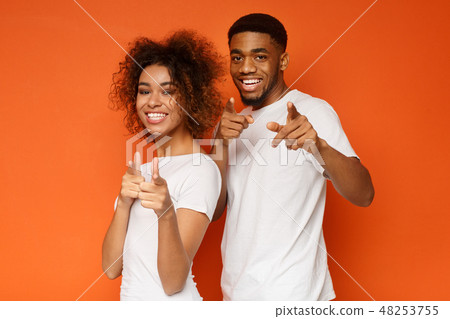 Joyful young couple pointing fingers at camera 48253755