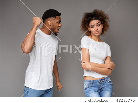 Young man threatening his girlfriend with his fist Young man threatening his girlfriend with his fist 48253779