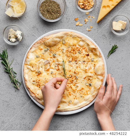 Chef decorating cheesy pizza with rocket salad Chef decorating cheesy pizza with rocket salad 48254222