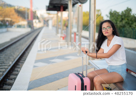 Young Beautiful Asian Tourist Woman Sitting While Waiting At The Train Station 48255170