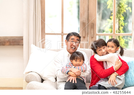 A grandparents who seems to be happy to embrace his grandchild who goes home from abroad to meet his grandpa grandpa 48255644