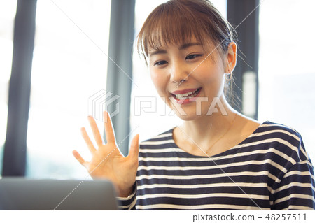 A young lady who talks to a friend by internet call 48257511