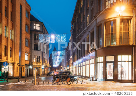 Riga, Latvia. Row Of Bicycles For Rent At Bike Parking On Valnu Street In Lighting In Night Riga, Latvia. Row Of Bicycles For Rent At Bike Parking On Valnu Street In Lighting In Night 48260135