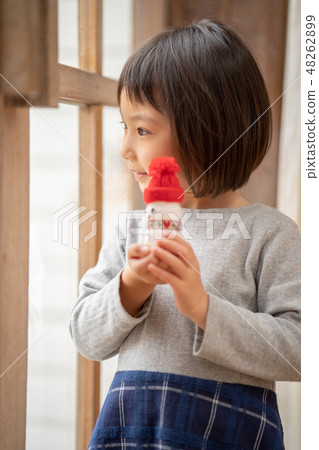 A cute kindergarten girl showing me a snowman for Christmas made with Yakult A cute kindergarten girl showing me a snowman for Christmas made with Yakult 48262899