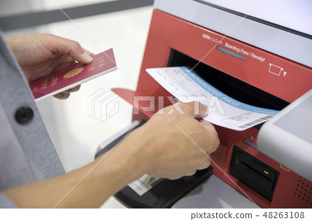 Male hand using an automatic check-in machine at the airport Male hand using an automatic check-in machine at the airport 48263108