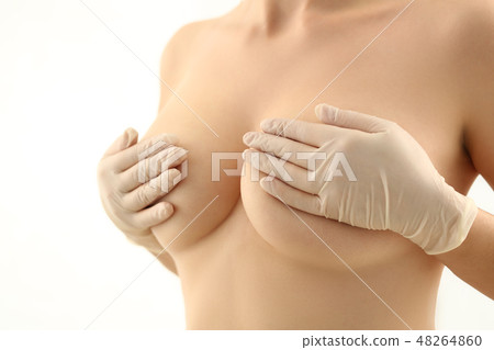 Female hand in gloves holding breast closeup 48264860