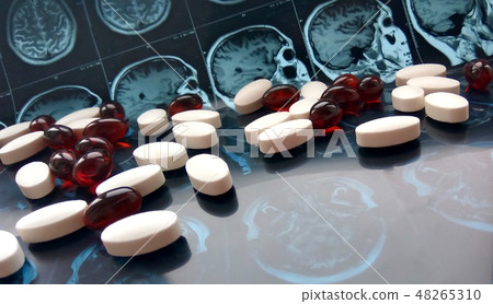 Pills on magnetic brain resonance scan background 48265310