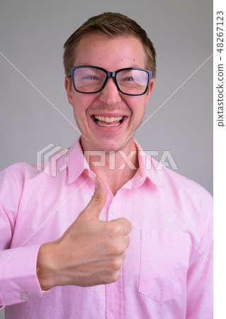 Face of young happy nerd businessman looking excited while giving thumbs up Face of young happy nerd businessman looking excited while giving thumbs up 48267123