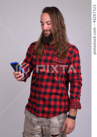 Portrait of young happy bearded hipster man using phone 48267322