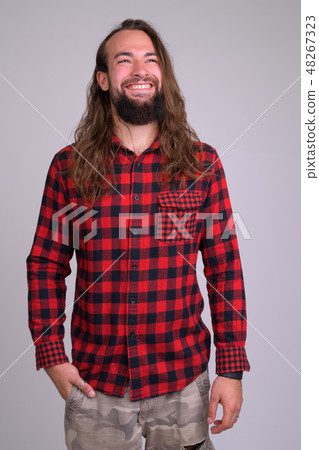 Portrait of young happy bearded hipster man thinking 48267323