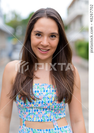 Beautiful happy multi-ethnic woman smiling in the streets outdoors Beautiful happy multi-ethnic woman smiling in the streets outdoors 48267702