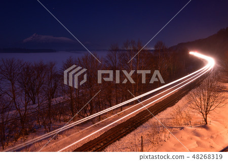 在冬天拍攝在大沼公園，北海道那賀町的大沼湖上運行的貨運列車的光線的風景 48268319