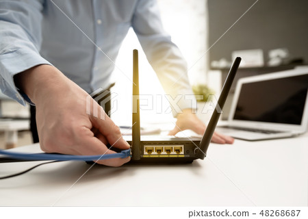 Man connects the cable to the router's socket 48268687