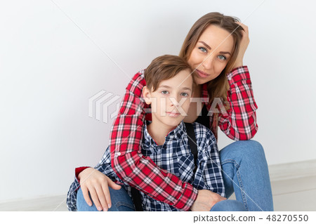 mothers day, children and family concept - cute teen boy with his young mother at home mothers day, children and family concept - cute teen boy with his young mother at home 48270550