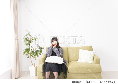 A young woman using a smartphone at home A young woman using a smartphone at home 48273634