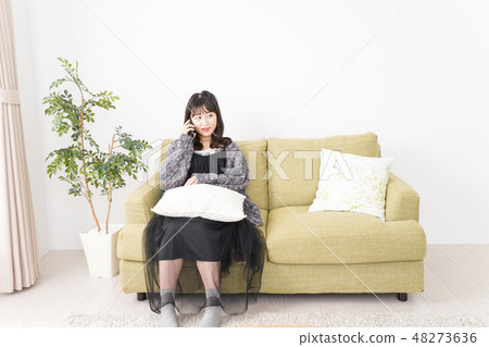 A young woman using a smartphone at home 48273636
