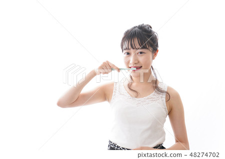 A young woman brushing her teeth 48274702