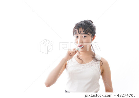 A young woman brushing her teeth 48274703