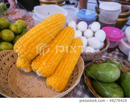Cooked corn placed in a basket 48276428
