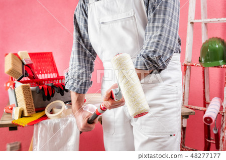 House painter at work on the construction site. 48277177