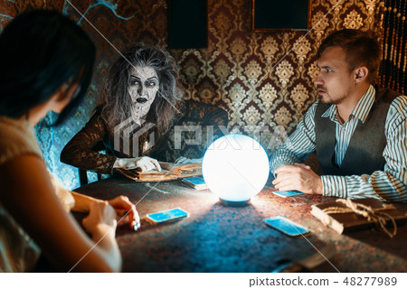 Family and witch at the table with crystal ball Family and witch at the table with crystal ball 48277989