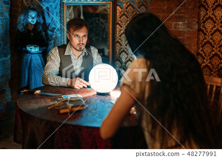 Young people at the table with crystal ball 48277991