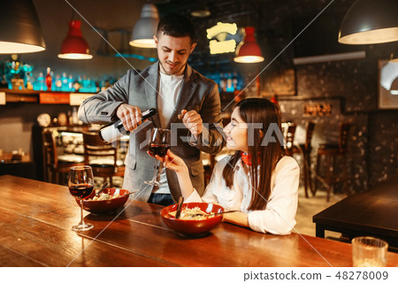 Couple at bar counter, romantic date celebration Couple at bar counter, romantic date celebration 48278009