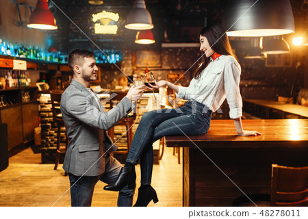 Woman flirting with man, couple at bar counter Woman flirting with man, couple at bar counter 48278011