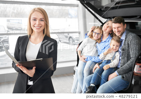 Manager of car dealership and happy family posing, smiling. 48279121