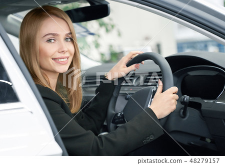 Blonde sitting in new automobile, buyer of car. 48279157