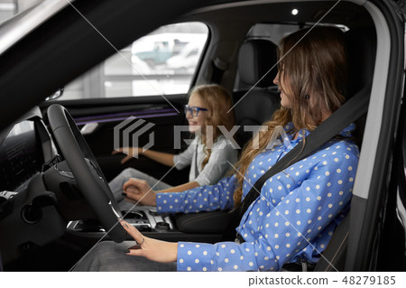 Woman and daughter testing new expensive automobile. 48279185