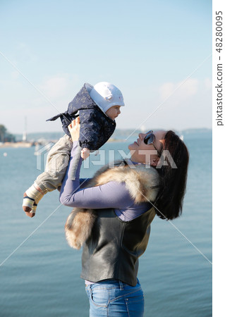 Mom and son have fun on the shore of the blue sea Mom and son have fun on the shore of the blue sea 48280095