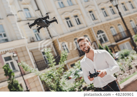 Leisure time. Man operating drone. Flying or hovering by remote control outdoors Leisure time. Man operating drone. Flying or hovering by remote control outdoors 48280901